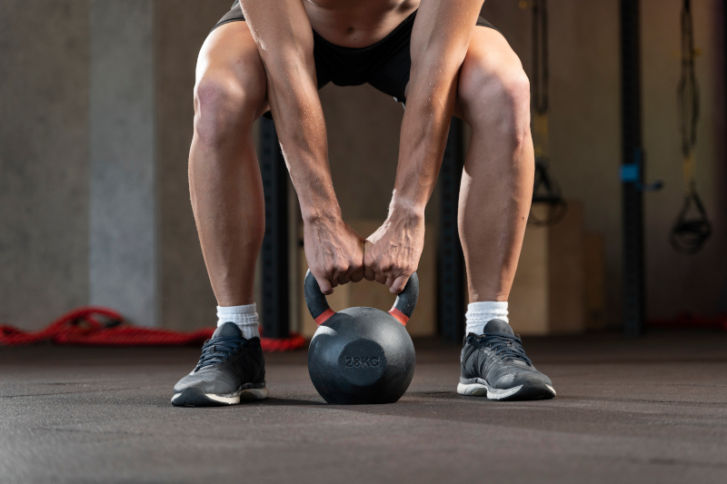 homme qui fait du crossfit avec un kettlebell