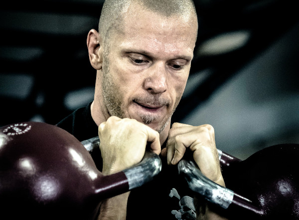 homme faisant une kettlebll press avec des kettlbell de 16 kg