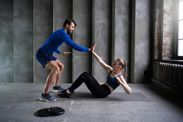Homme motive femme à améliorer sa force athlétique